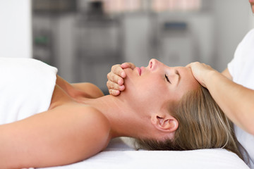 Fototapeta na wymiar Young woman receiving a head massage in a spa center.