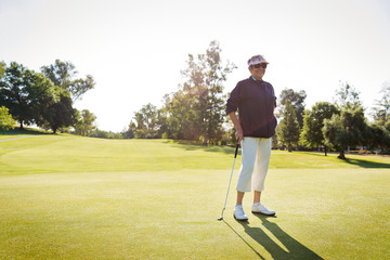 Portrait of female golfer standing on golf course 