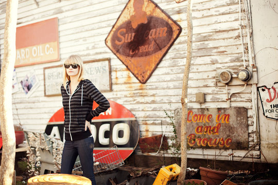 Young woman standing in front of vintage signs 