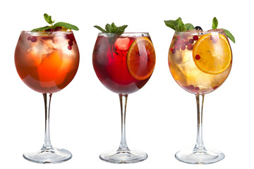 Alcoholic and non-alcoholic refreshing cocktails with mint, fruits and berries on a white background. Three cocktails in glass goblets.