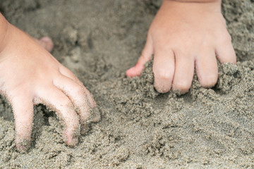close up kid's hand and finger, play and learn at the beach.