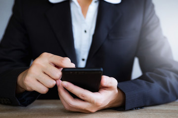 Closeup hand of business woman using smart mobile phone at office