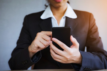 Closeup hand of business woman using smart mobile phone at office