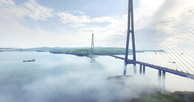 Ascending aerial view of Russian bridge, the longest cable-stayed bridge in the world. It connects the Russky Island and Vladivostok across the Eastern Bosphorus strait. Misty morning