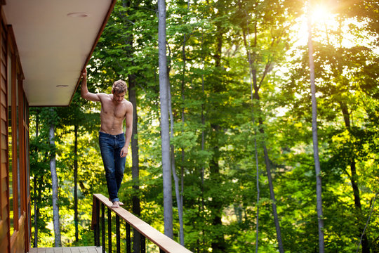 Shirtless young man walking on railing