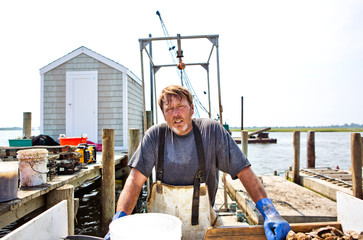 Oyster fisherman on dock with crates 