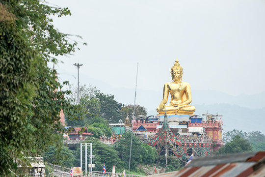 very big great gold buddha statue sitting beside river