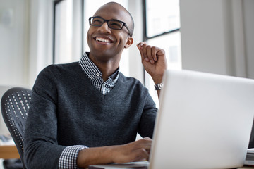 Young smiling man working with laptop 
