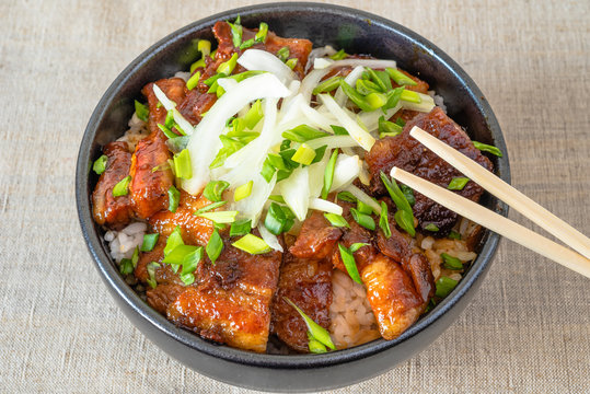 Rice bowl and fried pork belly, top view - a traditional Chinese and Korean dish.