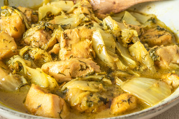 Chicken with Chinese cabbage in curry sauce in a bowl on a light background - a traditional Asian dish