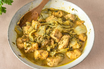 Chicken with Chinese cabbage in curry sauce in a bowl on a light background - a traditional Asian dish