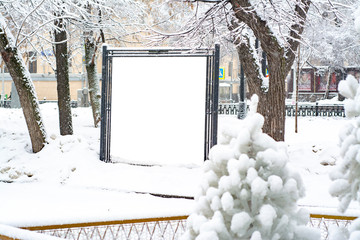 Snow-covered billboard on the boulevard in winter. With empty space isolated white color for your image or label.