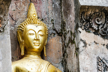 Great Gold Buddha statue with old background wall.