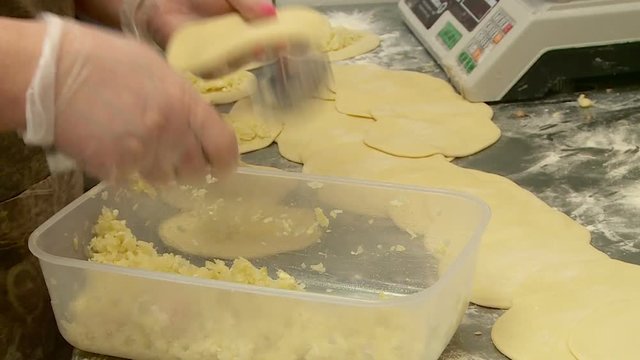 a worker in the bakery makes cheesecake pies and bakes them in the oven