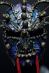 Iron demon mask with precious stones on dark background