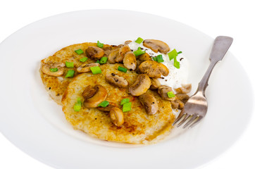 Plate with potato pancakes, fried mushrooms, isolated on white background.