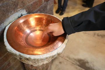 hand of the child and the holy water stew with blessed water
