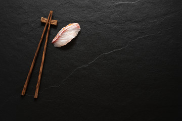 Fototapeta na wymiar space wood chopstick with fish slice on black marble background