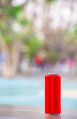 Canned drink red on the wooden chair Background blurry trees in garden