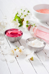 Obraz na płótnie Canvas beauty products and cherry blossom on white wood table