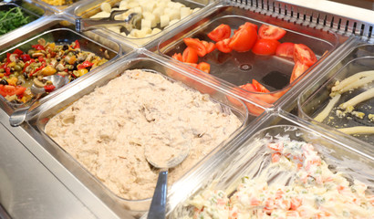 full trays of self service restaurant with many raw and cooked f