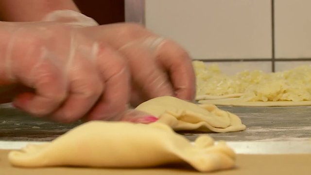 a worker in the bakery makes cheesecake pies and bakes them in the oven