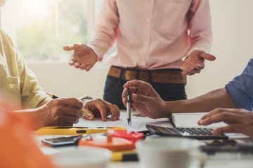 engineer people meeting working and pointing at a drawings in office for discussing. Engineering tools and construction concept.