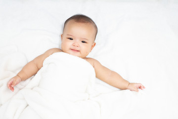 Happy Asian newborn baby under white towel after bath © StockerThings