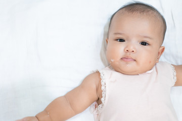 Asian newborn baby is vomitting or overfeeding. Close up baby girl vomit on white background.