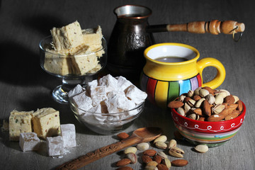 A mug of coffee and different oriental sweets: turkish delight, halva, almond and pistachio	
