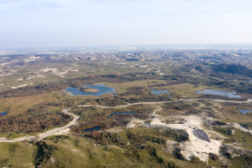 Dutch dunes by the sea from above in mystical late afternoon sun