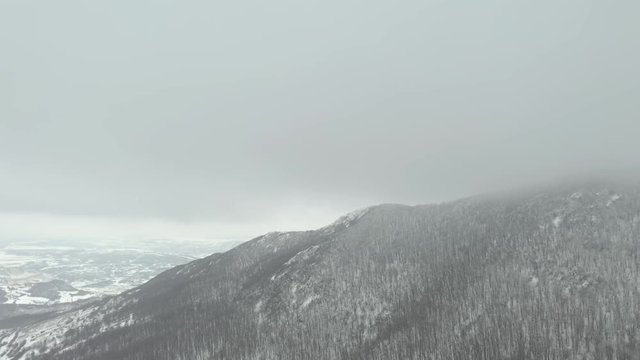 Slow flight over the cloudy top of mountain Veliki Krsh 4K drone video