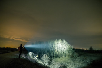Man outdoor adventure with flashlight 