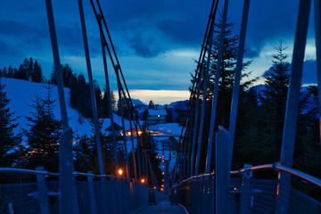 Naklejka premium Hängebrücke in Winterlandschaft mit Lampen