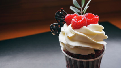 Delicious raspberry cupcakes on dark background - Handmade Sweet dessert, cupcake with butter cream and raspberry