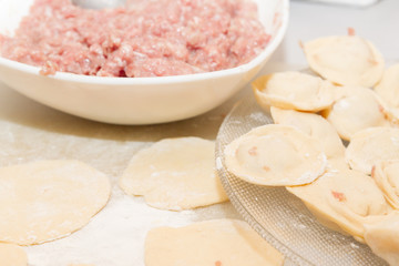 Raw and fresh dumplings lie on a glass plate
