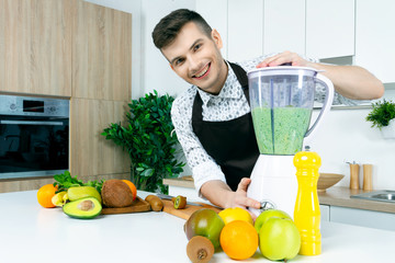 Young man male barista chef with apron doing cook fresh vitamin summer juice smoothie cocktail...