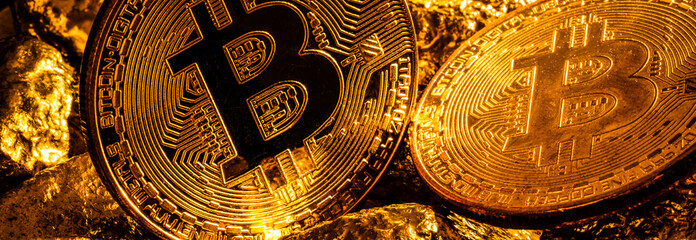 Closeup of big gold nugget and gold bitcoins coins on black background bitcoin cryptocurrency