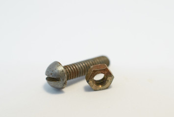 rusty bolt and nut lie next each other on gray background
