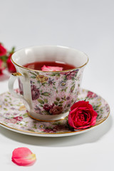 A cup of tea with a rose hip flower. Sunny spring evening. Therapeutic natural tea. Soft focus. 