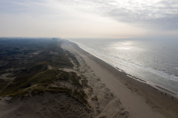 Dutch dunes by the sea from above in mystical late afternoon sun