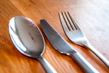 Cutlery - Spoon Knife and Fork on wooden table top
