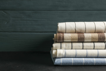 Stack of fabric napkins on black table, space for text