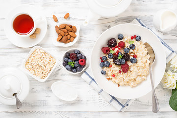 Healthy breakfast. Oatmeal with berries and nuts .