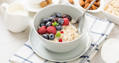 Healthy breakfast. Oatmeal with berries and nuts .