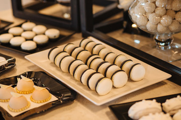 Sweet table. A plates of cakes and muffins with cream. Table with sweets, candy, buffet. Dessert table for a party goodies for the wedding. Close up. candy bar. Decorated delicious