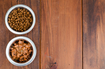 Metal bowls with various pet food.