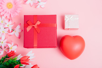 Red heart, flower and gift box on pink background