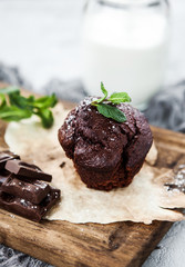 Chocolate cake or brownie on a wooden board with a bootle of milk