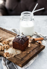 Chocolate cake or brownie on a wooden board with a bootle of milk
